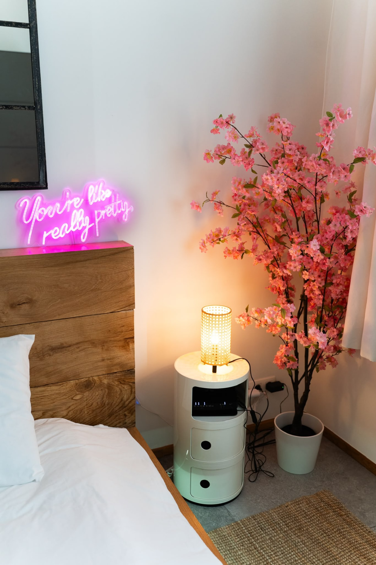 Détail de la chambre avec cerisier rose et enseigne lumineuse
