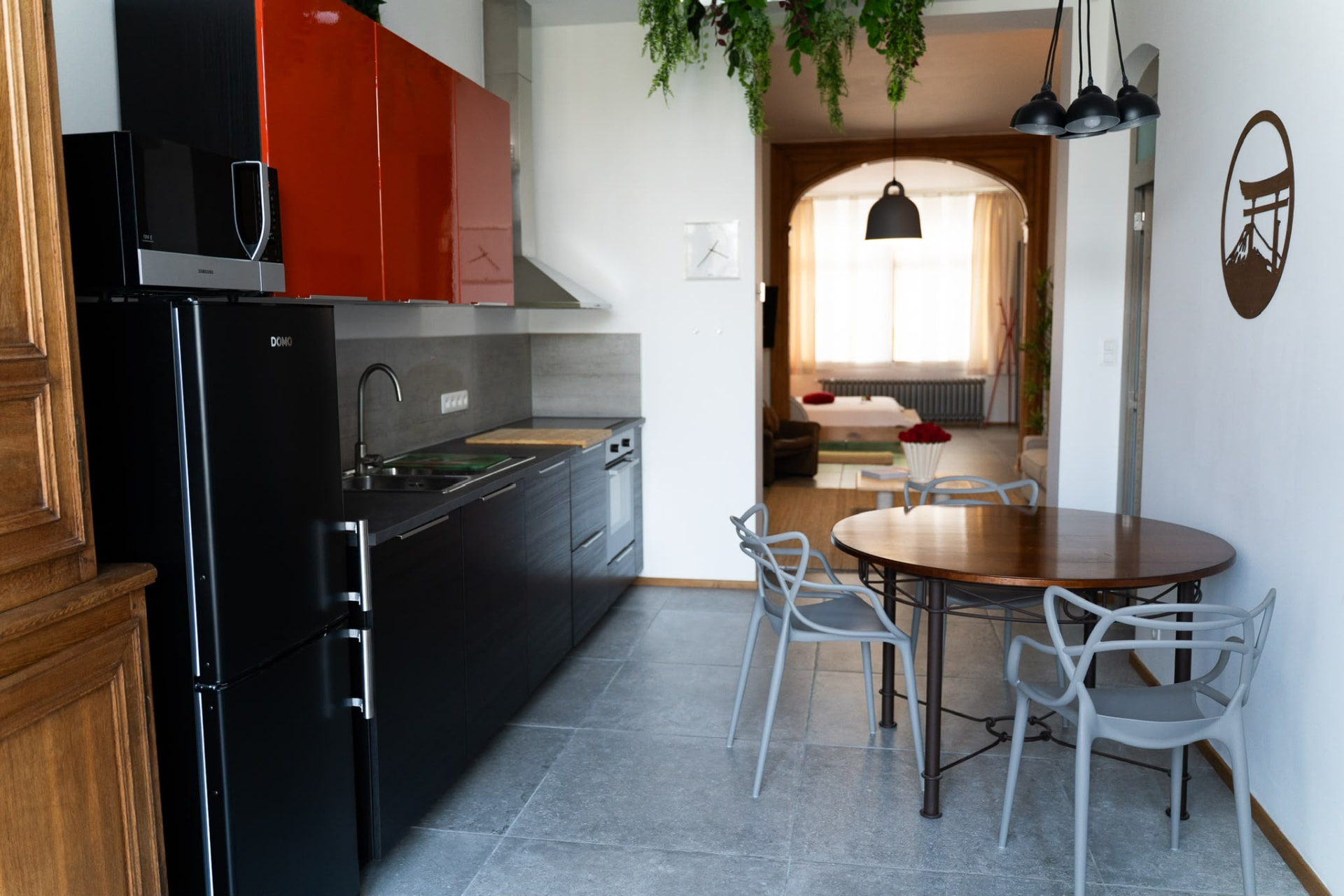 Cuisine équipée avec réfrigérateur, table à manger et vue vers le salon