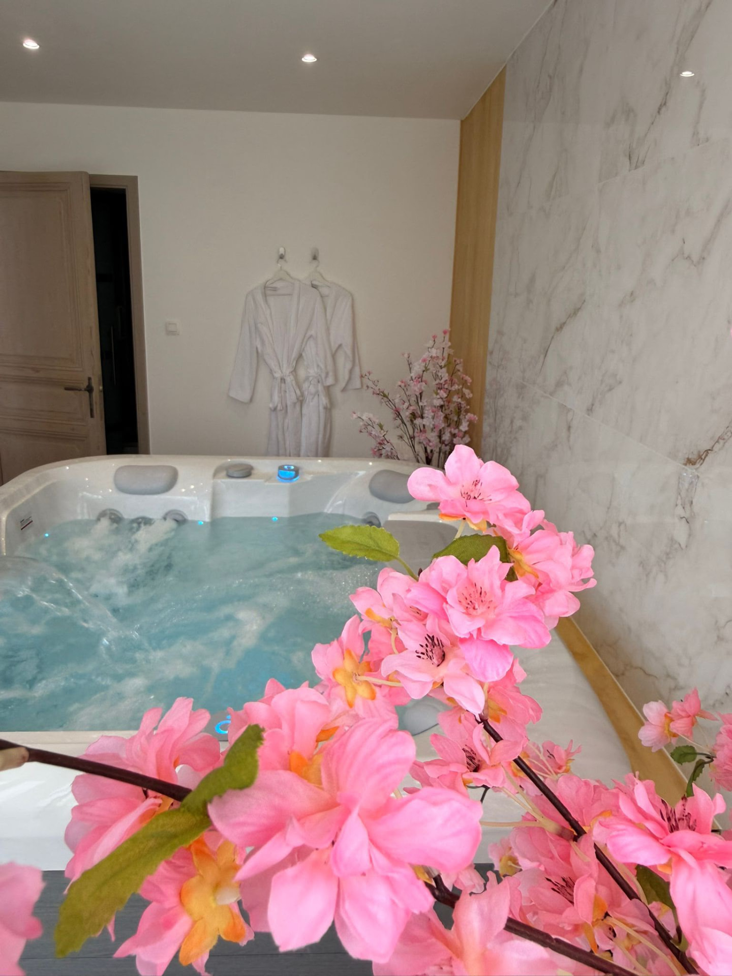 Fleurs de cerisier roses au premier plan du spa privé