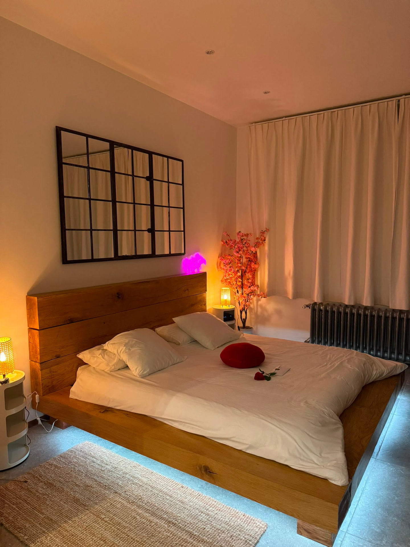 Lit en bois de la chambre éclairé dans des tons doux et chaleureux