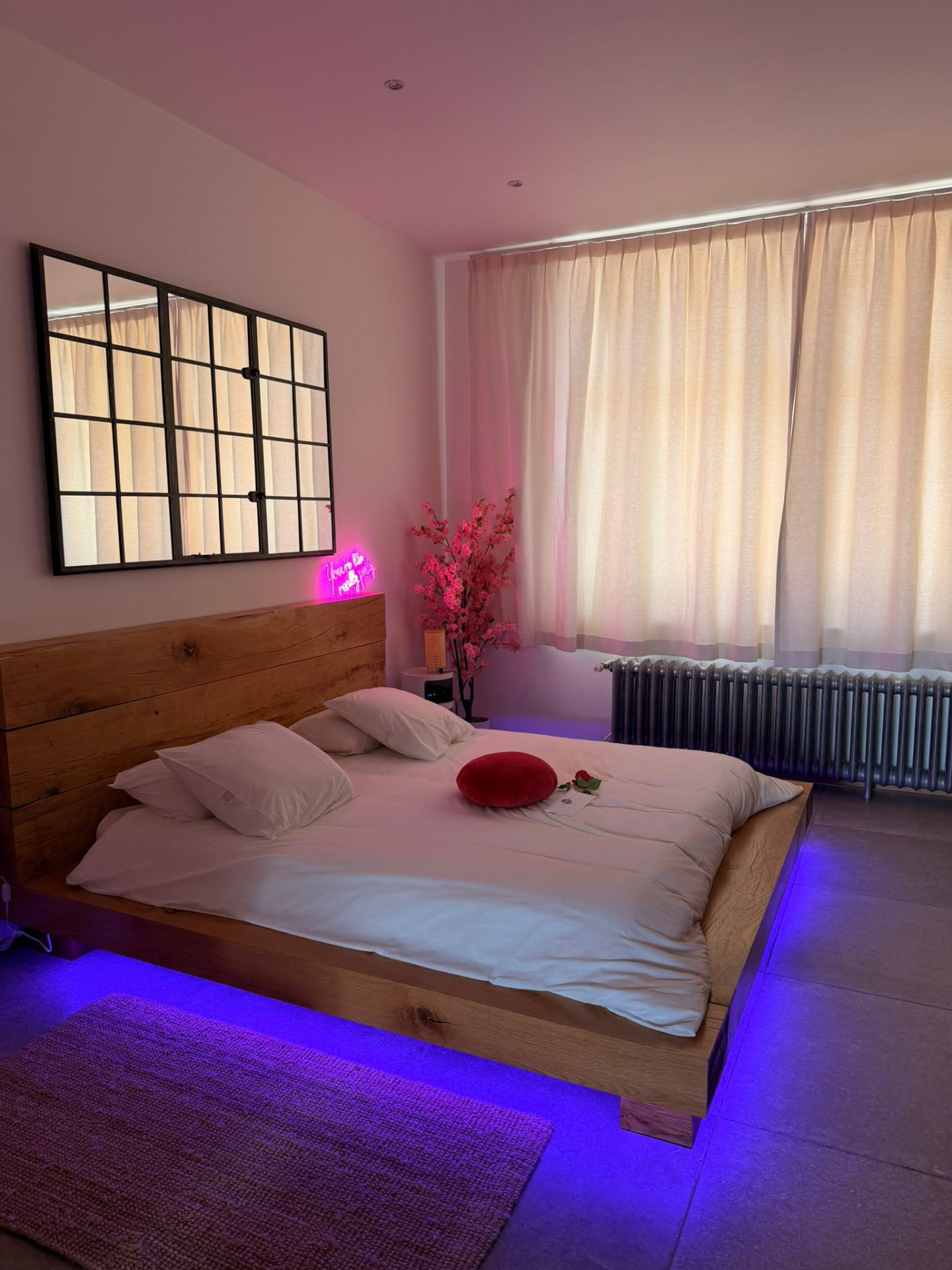 Chambre de L'Exotic Chimay avec éclairage rose et bleu autour du lit